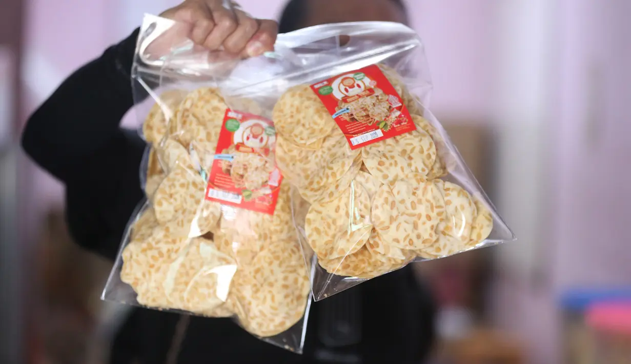 Pekerja menunjukkan salah satu hasil produksi pembuatan keripik tempe di rumah usaha Keripik Tempe Mama Tina, Kebayoran Baru, Jakarta Selatan, Kamis (7/5/2026). Keripik Tempe Mama Tina merupakan usaha rumahan memproduksi keripik tempe dengan beragam varian rasa seperti original bawang putih, balado, barbeque, hingga sapi panggang. (merdeka.com/Arie Basuki)