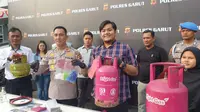 Kapolres Garut AKBP Rohman Yonky Dilatha, menunjukan barang bukti gas oplosan non subsidi dalam rilis kasus di Mapolres Garut, Rabu (23/8/2023) petang. (Liputan6.com/Jayadi Supriadin)