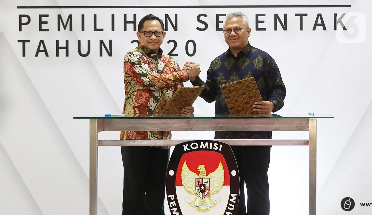 Mendagri, Tito Karnavian (kiri) dan Ketua KPU Arief Budiman saat Serah Terima Data Penduduk Potensial Pemilih Pemilihan (DP4) untuk Pemilihan Serentak 2020 di Jakarta, Kamis (23/1/2020). Kemendagri menyerahkan DP4 dengan jumlah 105 juta. (Liputan6.com/Herman Zakharia)