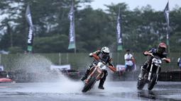 Richard Dibben (kanan), pebalap asal Selandia Baru mencoba menyalip Eric Chia (kiri) pebalap asal Singapura  pada ajang FIM Asia Supermoto 2016 di Kompleks Stadion Kanjuruhan, Malang, Sabtu (8/10/2016) (Bola.com/Reza Bachtiar)
