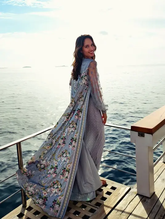 Lebaran di tengah perairan Raja Ampat, Cinta Laura terlihat anggun busana serba biru. Menampilkan setelan polkadot dengan atasan puffy sleeve transparan dan cape bermotif bunga [@claurakiehl]