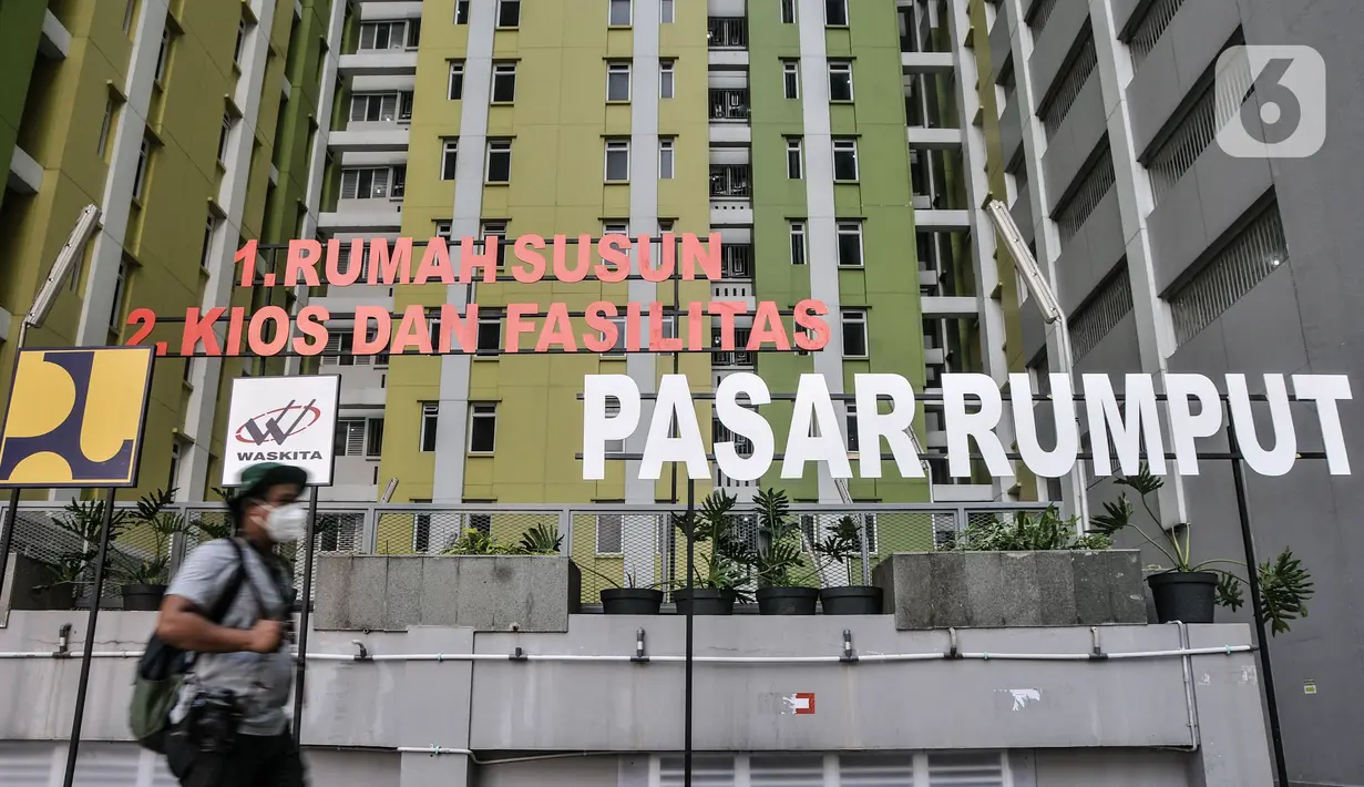 Jurnalis melintas di depan fasilitas sosial dan umum yang berada di lantai 3 Rusun Pasar Rumput, Manggarai, Jakarta, Senin (20/9/2021). Rusun Pasar Rumput siap menampung warga bantaran Ciliwung di Ibu Kota yang terdampak program normalisasi sungai sebagai penanganan banjir. (merdeka.com/Iqbal S. Nug