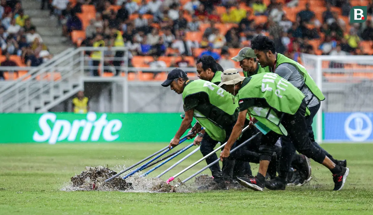 Sejumlah petugas menyingkirkan air yang menggenangi lapangan Jakarta International Stadium (JIS) jelang laga perempat final Piala Dunia U-17 2023 antara Timnas Brasil U-17 melawan Timnas Argentina U-17, Jumat (24/11/2023). (Bola.com/Bagaskara Lazuardi)