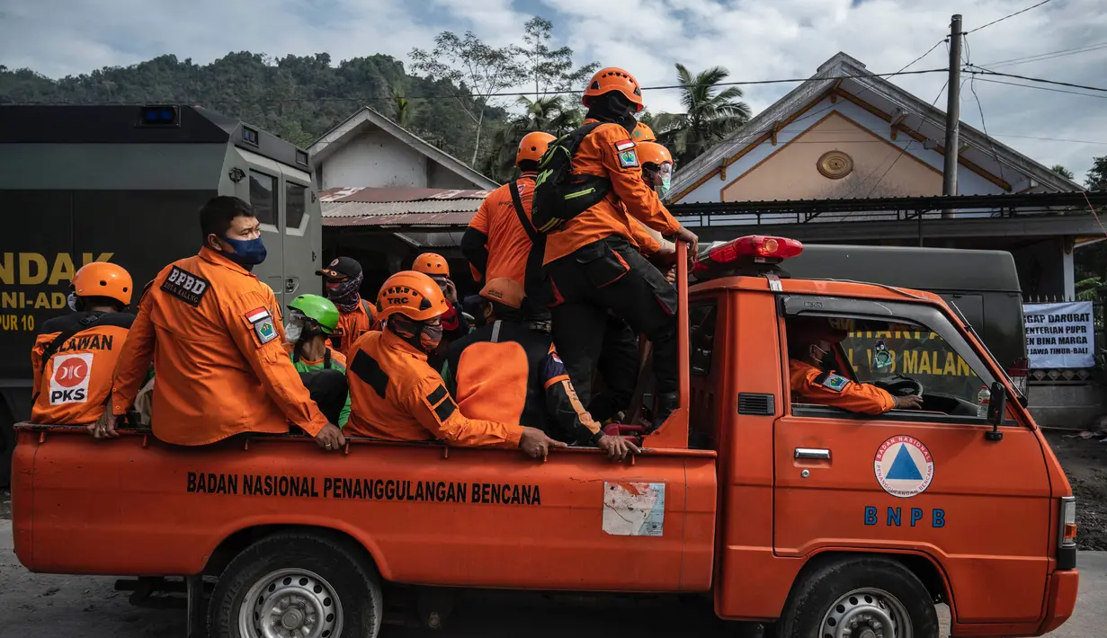 Tim penyelamat tiba untuk mencari korban di rumah yang terkubur abu vulkanik letusan Gunung Semeru di Desa Sumber Wuluh, Lumajang, Jawa Timur, Selasa (7/12/2021). Letusan Gunung Semeru menewaskan sedikitnya 34 orang. (AFP/Juni Kriswanto)