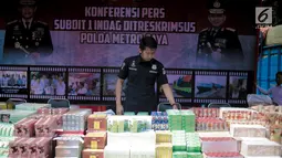 Petugas Subdit I Reskrimsus Polda Metro Jaya (PMJ) merapikan barang bukti saat rilis kasus penyelundupan barang ilegal di Halaman Ditreskrimsus Polda Metro Jaya, Rabu (14/8/2019). Petugas Subdit I Reskrimsus Polda Metro Jaya berhasil mengamankan empat tersangka. (Liputan6.com/Faizal Fanani)