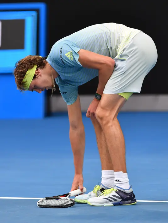 Petenis Jerman, Alexander Zverev menginjak raketnya setelah frustasi dikalahkan petenis Korea Selatan, Chung Hyeon di turnamen Australia Terbuka, 20 Januari 2018. Kalah bermain, Zverev kesal dan membanting raketnya hingga rusak. (SAEED KHAN/AFP)