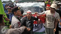 Aparat berusaha mengamankan massa aksi dari Front Pancasila saat berusaha masuk menuju Hotel Aryaduta, Jakarta, Senin (18/4). Mereka menolak Simposium PKI yang dapat dimanfaatkan menghidupkan kembali paham komunis. (Liputan6.com/Faizal Fanani)