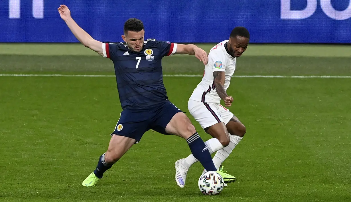 Penyerang Inggris, Raheem Sterling berebut bola dengan pemain Skotlandia, John McGinn pada pertandingan grup D Euro 2020 di stadion Wembley, di London, Jumat (18/6/2021). Skotlandia kini telah mengoleksi satu poin dari dua pertandingan. (Facundo Arrizabalaga/Pool via AP)