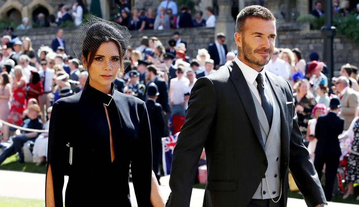 Legenda Timnas Inggris, David Beckham, bersama istrinya Victoria Beckham saat menghadiri upacara pernikahan Pangeran Harry dan Meghan Markle di St George Chapel di kastil Windsor, (19/5/2018). (Photo by Chris Radburn / POOL / AFP)
