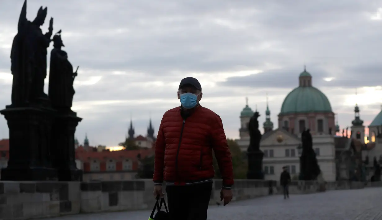 Seorang pria melintasi Jembatan Charles yang dibangun pada abad pertengahan di Praha, Republik Ceko, Kamis (8/10/2020). Republik Ceko pada Rabu (7/10) melaporkan sebanyak 5.335 kasus virus corona baru yang dikonfirmasi di negara itu, melampaui rekor hari sebelumnya. (AP Photo/Petr David Josek)