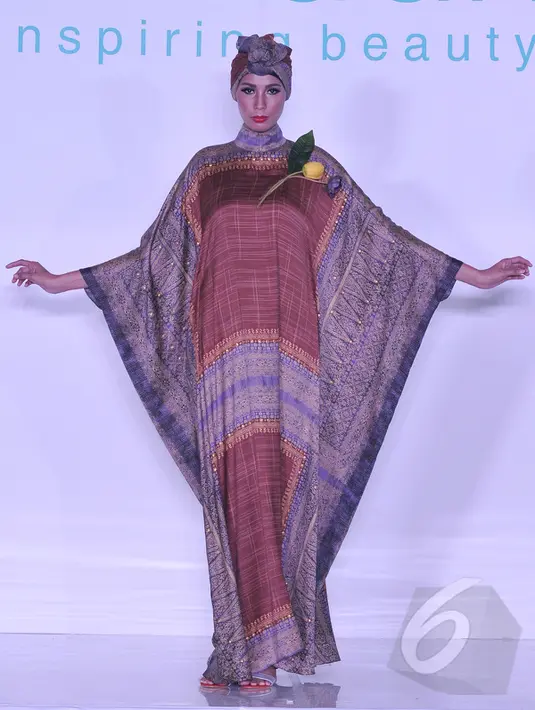 Model memperagakan busana muslim rancangan Itang Yunasz bertajuk Puspa Ragam Andalas di Pusat Grosir Blok B Tanah Abang, Jakarta, Kamis (30/4/2015). (Liputan6.com/Herman Zakharia)