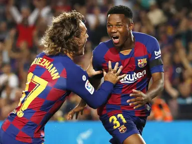 Pemain Barcelona, Ansu Fati, bersama Antoine Griezmann merayakan gol yang dicetak ke gawang Valencia pada laga La Liga di Stadion Camp Nou, Sabtu (14/9). Barcelona menang 5-2 atas Valencia. (AP/Joan Monfort)
