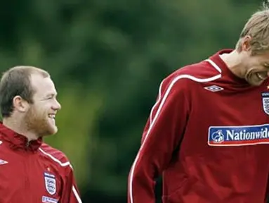 Wayne Rooney and Peter Crouch share a joke as they walk to the training ground for training at London Colney, North London, on October 7, 2008. AFP PHOTO/Glyn Kirk
