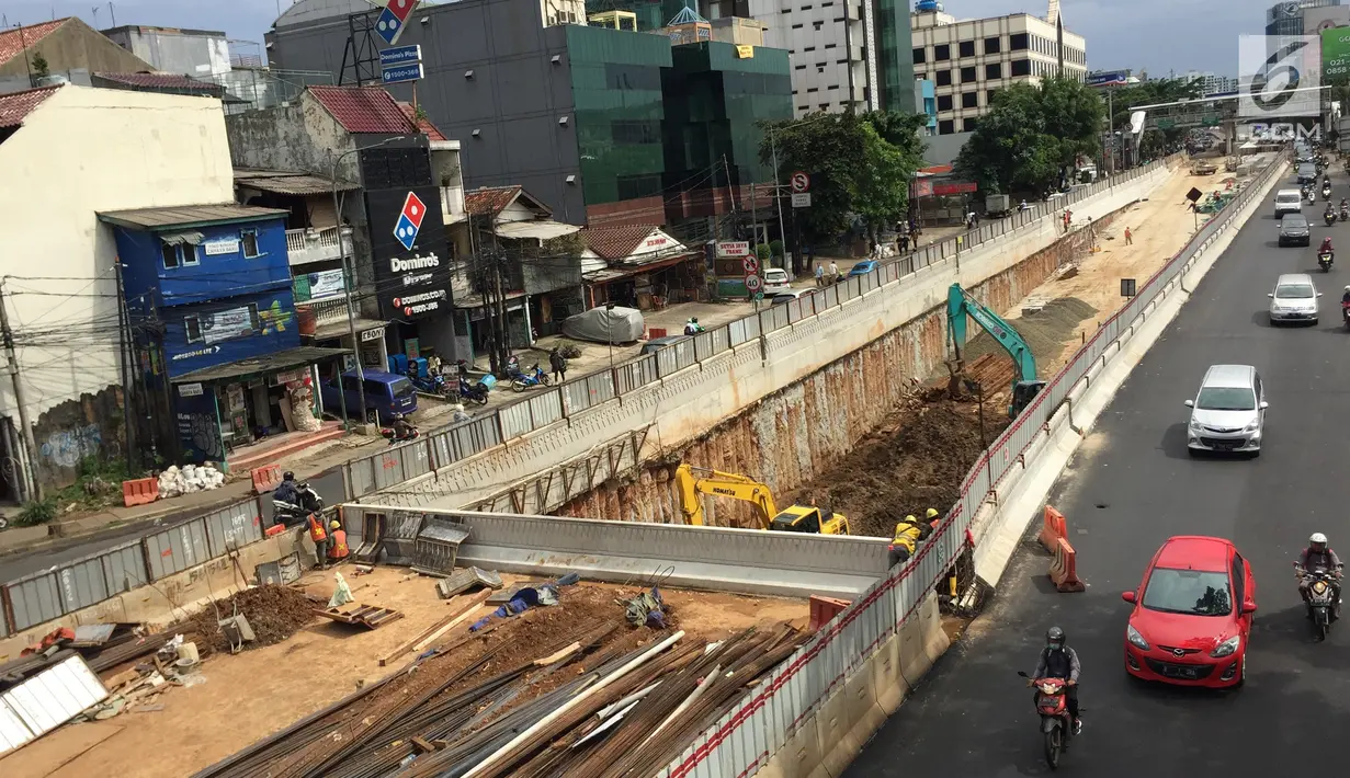 Kendaraan melintas di samping pembangunan proyek underpass Mampang-Kuningan, Jakarta, Senin (29/1). Proyek terowongan ini molor disebabkan adanya instalasi kabel PT PGN dan Palyja yang belum bisa dipindahkan. (Liputan6.com/Immanuel Antonius)