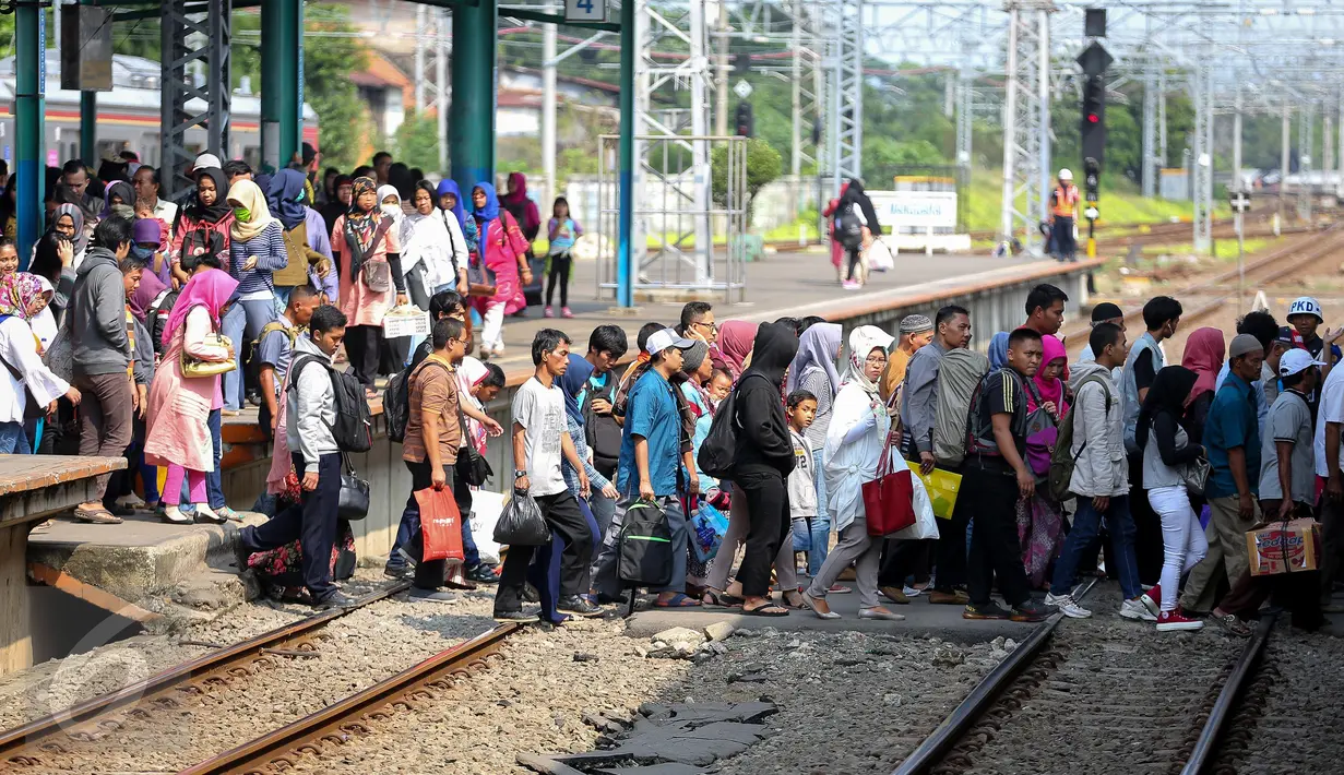 Sejumlah penumpang Comuter Line menyebrang antar peron di Stasiun Manggarai, Jakarta, Selasa (28/3). Jumlah kenaikan penumpang pada hari libur Nyepi ini meningkat hingga 70 % dibanding hari biasa. (Liputan6.com/Faizal Fanani)