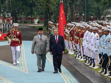 Presiden Republik Indonesia Prabowo Subianto (kiri tengah) dan Perdana Menteri China Li Qiang memeriksa pasukan kehormatan saat upacara penyambutan di Istana Kepresidenan, Jakarta pada 25 Mei 2025. (YASUYOSHI CHIBA/AFP)