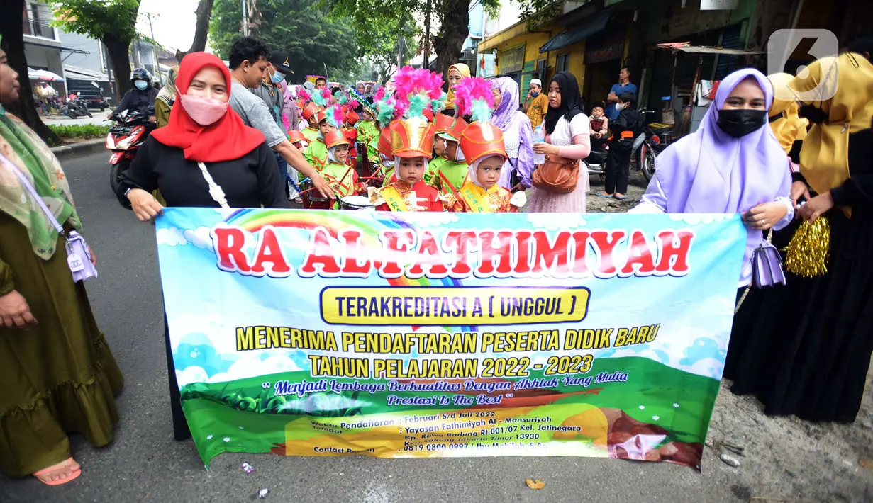 Sejumlah murid dan orangtua TK Islam berjalan bersama sambil membawa poster di Jalan Raya Radjiman Widyo Ningrat, Jakarta, Sabtu (26/3/2022). Pemerintah telah memperbolehkan melaksanakan kewajiban selama bulan suci Ramadan dengan protokol kesehatan yang ketat. (merdeka.com/Imam Buhori)