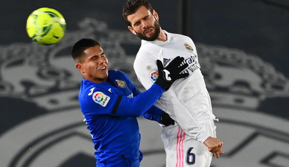 Penyerang Getafe,  Cucho Hernandez (kiri) berebut bola udara dengan bek Real Madrid, Nacho pada pertandingan lanjutan La Liga Spanyol di stadion Alfredo di Stefano di Madrid, Spanyol, Rabu (10/2/2021). El Real menyalip Barcelona yang harus turun ke posisi ketiga dengan koleksi 43 poin dari 21 laga.