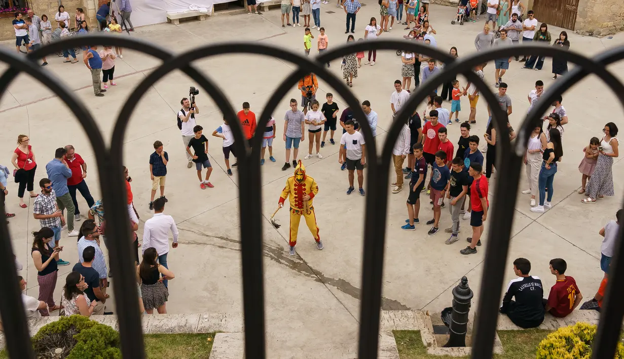 Pria berkostum setan tiba untuk mengejar kerumunan orang pada tradisi 'setan melompati bayi' atau disebut juga El Salto del Colacho di desa Castrillo de Murcia, bagian utara Spanyol, 23 Juni 2019. Festival melompati bayi ini digelar pada bulan Juni tiap tahunnya. (CESAR MANSO/AFP)