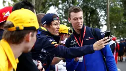 Pembalap F1 Toro Rosso, Daniil Kvyat berselfie bersama penggemarnya saat tiba di Sirkuit Melbourne Grand Prix di Melbourne, Jumat (15/3). (Reuters/Edgar Su)