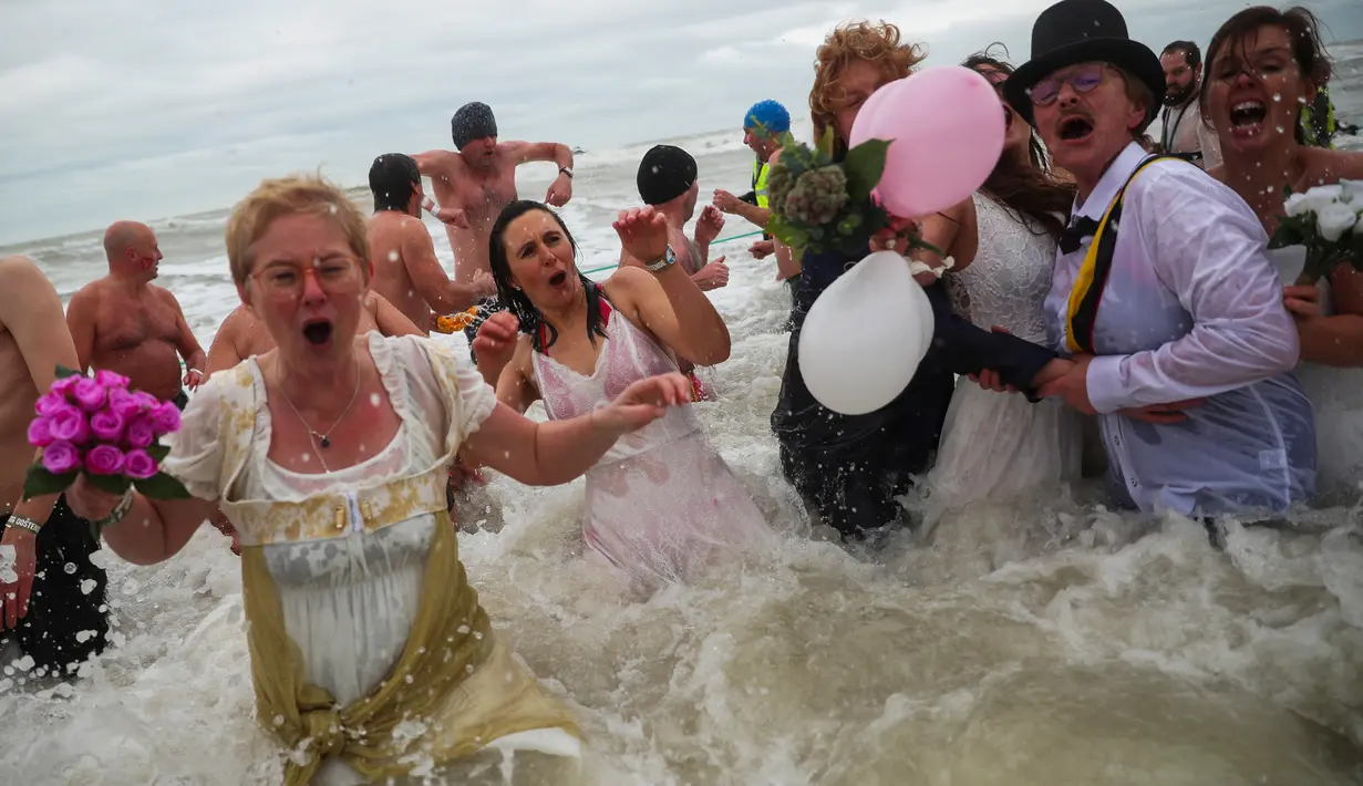 Orang-orang dengan kostum warna-warni menyerbu perairan Laut Utara  untuk merayakan akhir pekan pertama Januari 2020 di Ostend, Belgia, Sabtu (4/1/2020). Cuaca dingin tak menghalangi mereka untuk menceburkan diri ke laut yang merupakan salah satu tradisi tahun baru. (AP/Francisco Seco)