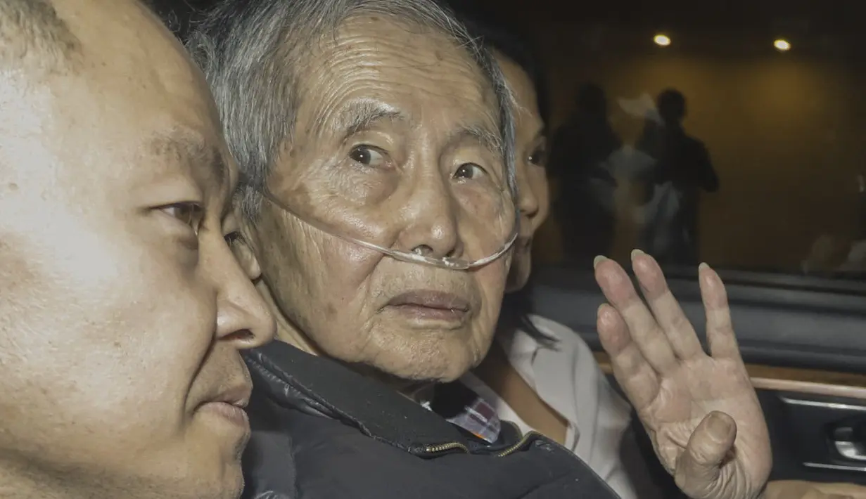 Dia duduk di kursi belakang bersama putra dan putrinya, politisi sayap kanan Keiko Fujimori. (Renato PAJUELO / AFP)