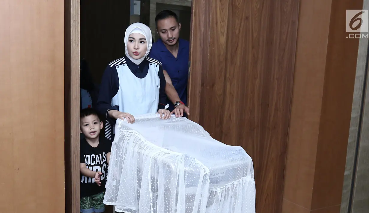 Soraya Larasati dan suaminya Doni Amaldi dan putra pertamanya menuju ruang jumpa pers, Jakarta, Kamis (8/6). Soraya Larasati melahirkan anak keduanya dengan berat 3,2 kilogram dan panjang 49 sentimeter. (Liputan6.com/Herman Zakharia)