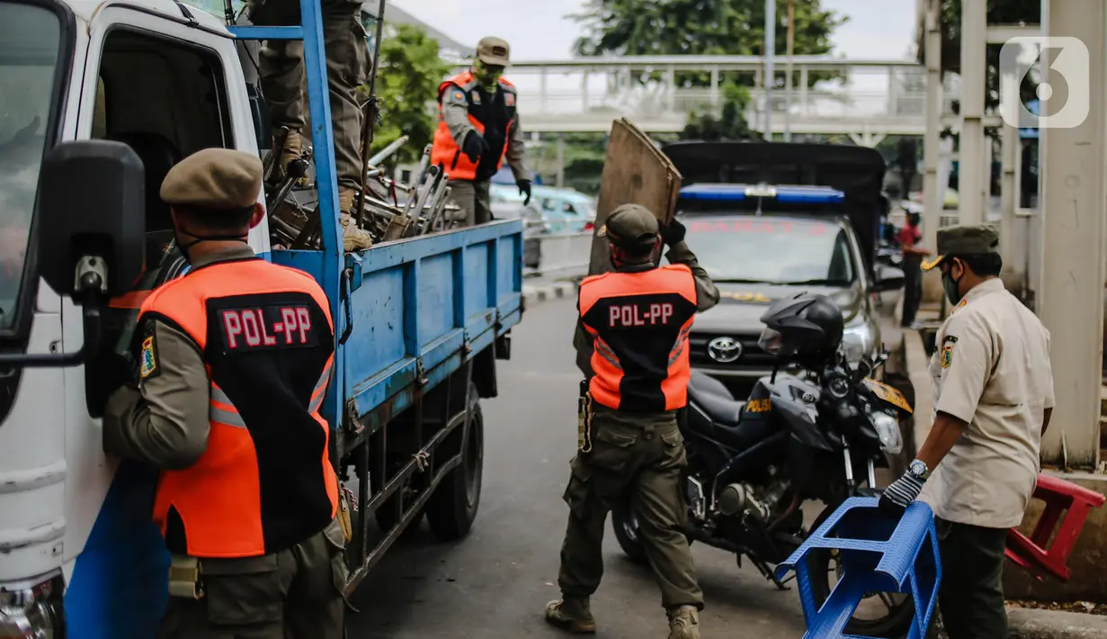 Petugas Satpol PP menyita dagangan pedagang yang nekat berjualan saat masa pandemi COVID-19 di kawasan Pasar Tanah Abang, Jakarta, Jumat (22/5/2020). Gubernur DKI Jakarta Anies Baswedan menambah PSBB selama 14 hari mulai tanggal 22 Mei 2020. (Liputan6.com/Faizal Fanani)