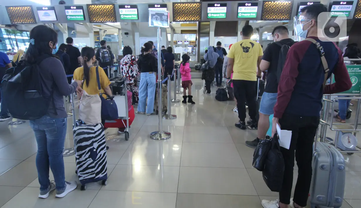 Sejumlah calon penumpang memadati loket check in Terminal3 Bandara Soekarno Hatta, Tangerang, Banten, Jumat (18/12/2020). PT Angkasa Pura II (Persero) atau AP II memprediksi lalu lintas sebanyak 2,1 juta penumpang pada periode angkutan Natal dan Tahun Baru 2021. (Liputan6.com/Angga Yuniar)