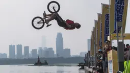 Seorang pesepeda melompat ke Danau Timur menggunakan sepeda BMX dalam ajang tahunan festival lompat air (water jump) BMX di Wuhan, ibu kota Provinsi Hubei, China tengah, pada 22 Agustus 2020. (Xinhua/Xiao Yijiu)