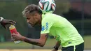 Neymar menahan bola dipunggungnya saat meminta minum pada staf pelatih saat latihan menjelang kontra Meksiko, Brasil, Senin (16/6/2014) (AFP Photo/ARI VERSIANI)