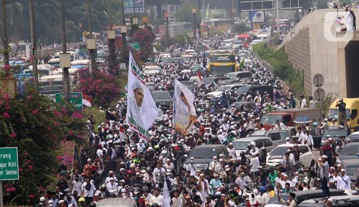 Ratusan massa berkonvoi mengawal Rizieq Shihab usai tiba di Bandara Soekarno-Hatta, Tangerang, Banten, Selasa (10/11/2020). Konvoi tersebut dilakukan untuk mengawal perjalan Rizieq Shihab menuju kediamannya di Petamburan, Jakarta. (Liputan6.com/Angga Yuniar)