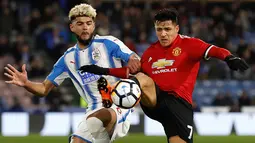 Pemain Manchester United Alexis Sanchez berebut bola dengan pemain Huddersfield Town Philip Billing pada pertandingan putaran kelima Piala FA di John Smith's Stadium, Minggu (18/2). MU melaju ke perempatfinal setelah menang 2-0. (Martin Rickett/PA via AP)