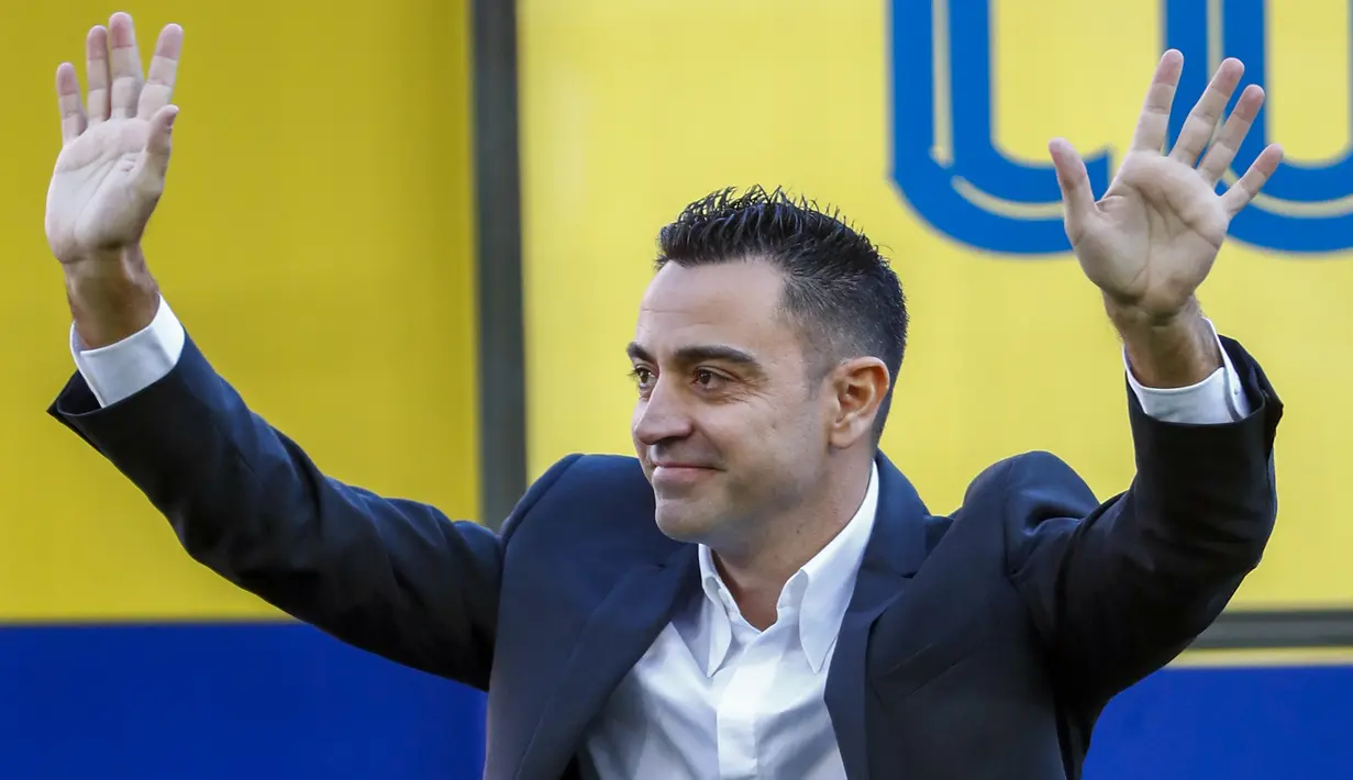 Xavi pun yang kini tampil berbeda dengan balutan jas parlente membalas sambutan para fans dengan lambaian tangan penuh kehangatan. (AP/Joan Monfort)