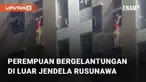 Seorang perempuan bergelantungan di luar jendela sebuah rusunawa mengundang perhatian