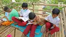 Sejumlah murid SD sedang membaca buku di sekolah alam Sukawangi, Kabuapaten Bekasi, Jawa Barat, Senin (30/11/2020). Kegiatan bermain di alam terbuka menjadi solusi bagi para murid untuk menghilangkan rasa jenuh usai belajar dimasa pandemi COVID-19. (Liputan6.com/Herman Zakharia)