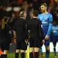 Bek Arsenal, Per Mertesacker (kanan) berbicara kepada wasit Jonathan Moss (kedua kiri) setelah pertandingan melawan Nottingham Forest di pertandingan babak ketiga Piala FA di City Ground, Nottingham, Inggris (7/1). (AFP Photo/Oli Scarff)