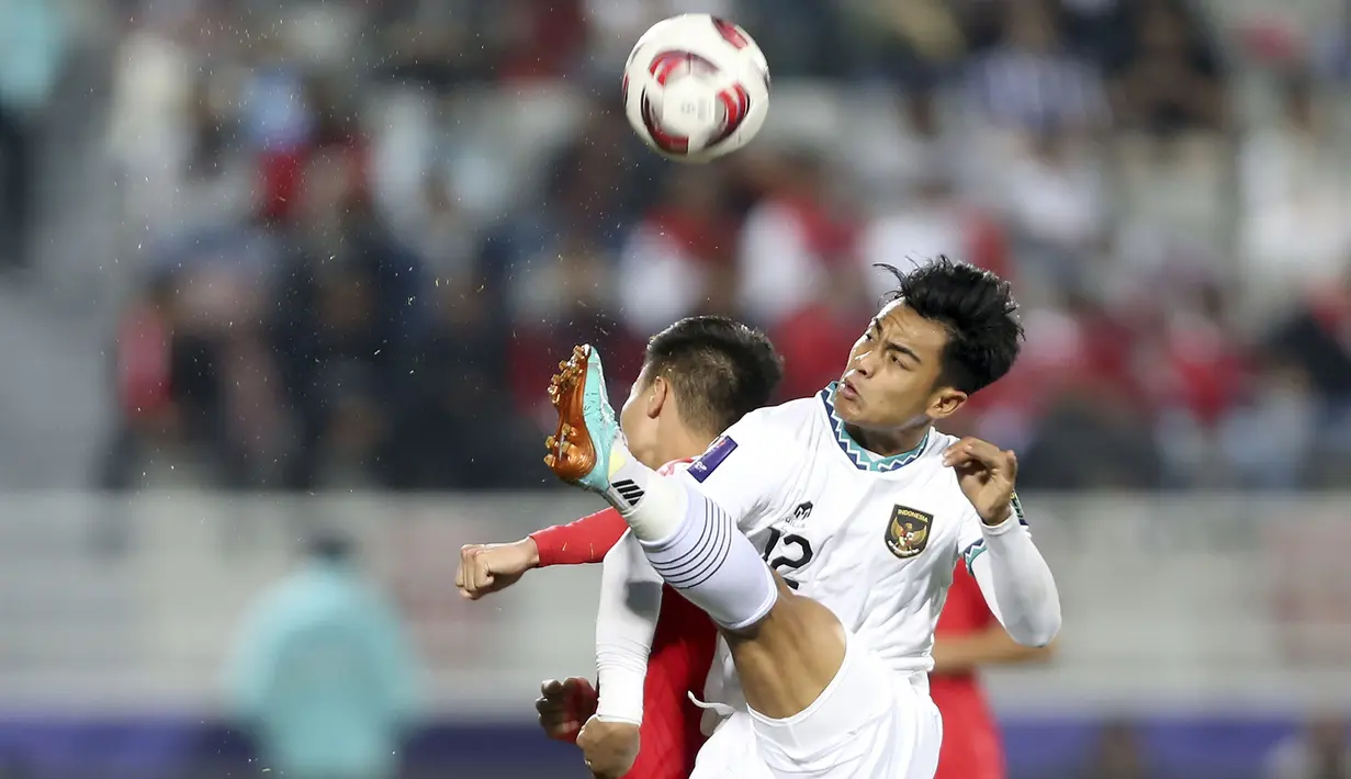 Bek Timnas Indonesia, Pratama Arhan berusaha menghalau bola dari ancaman gelandang Vietnam, Nguyen Quang Hai pada laga kedua Grup D Piala Asia 2023 di Abdullah Bin Khalifa Stadium, Doha, Qatar, Jumat (19/1/2024). (AP Photo/Hussein Sayed)