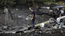 Anggota Kementerian Darurat Ukraina mencari bukti baru jatuhnya pesawat Malaysia Airlines MH-17 diantara sisa puing-puing di desa Hrabove, Donetsk, Ukraina, (20/7/2014). (REUTERS/Maxim Zmeyev)
