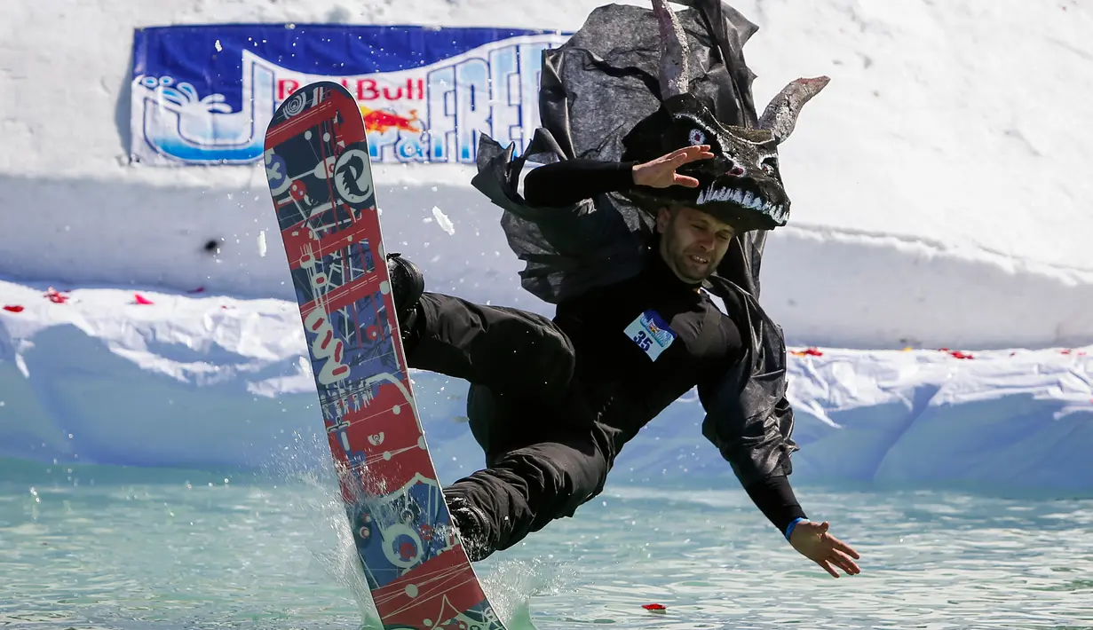 Peserta berkostum naga melompat ke dalam air dari salju selama kontes Jump Red Bull dan Freeze di ski resort Chimbulak, Kazakhstan (22/3). Dalam kontes ini para peserta mengundang tawa penonton yang menyaksikan. (REUTERS/Shamil Zhumatov)