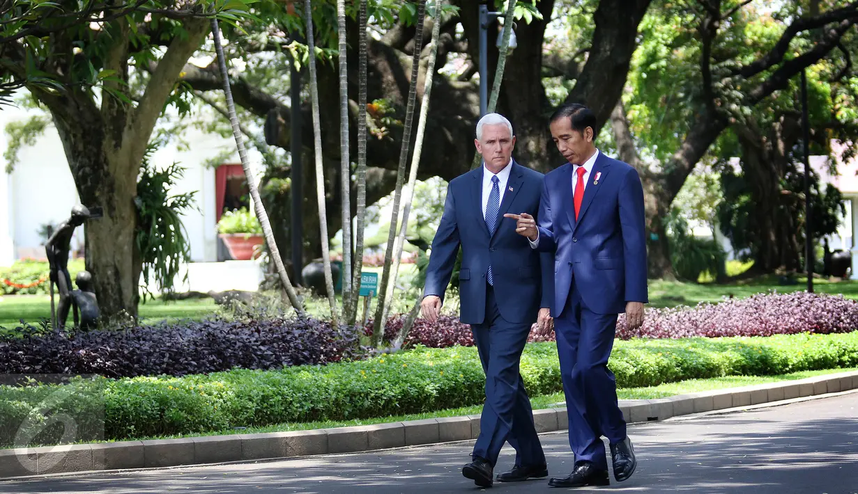 Presiden Joko Widodo (kanan) berjalan bersama saat menyambut kedatangan Wakil Presiden Amerika Serikat Michael R. Pence (Mike Pence) di halaman Istana Merdeka, Jakarta, Kamis (20/4). (Liputan6.com/Angga Yuniar)