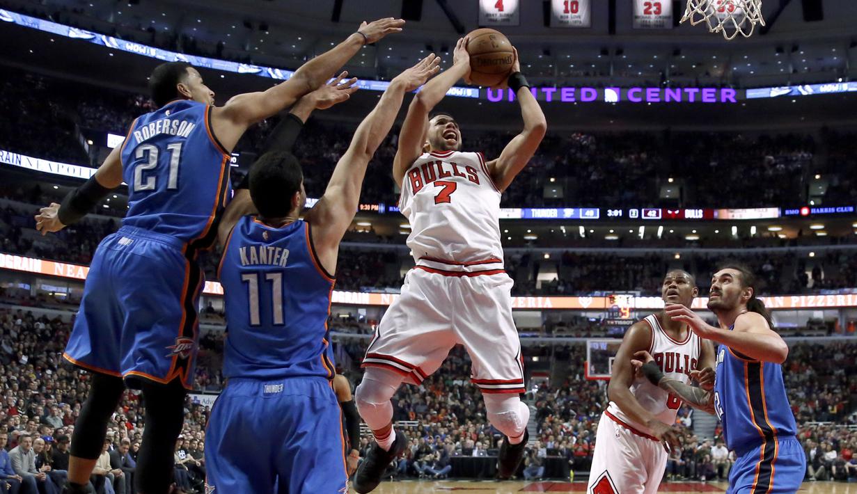 Pemain Chicago Bulls, Michael Carter-Williams (7) melakukan tembakan melewati hadangan dua pemain Oklahoma City Thunder pada laga NBA basketball game di United Center, (9/1/2017). Thunder menang 109-94. (AP/Charles Rex Arbogast)