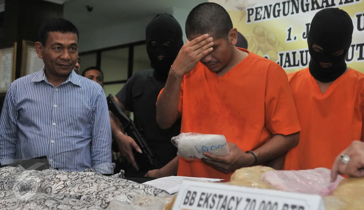 Salah satu tersangka diperlihatkan petugas saat Press Release di kantor Bareskrim Cawang, Jakarta, Selasa (7/3). Bareskrim berhasil mengungkap kasus peredaran narkotika yang melibatkan sekuriti bandara I Gusti Ngurah Rai Bali.  (Liputan6.com/Yoppy Renato)