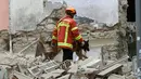 Petugas menggunakan anjing pelacak untuk menemukan korban  terperangkap di puing bangunan yang runtuh di Marseille, selatan Prancis, Senin (5/11). Belum diketahui secara pasti penyebab runtuhnya dua bangunan tersebut. (AP/Claude Paris)