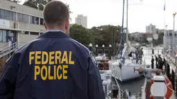 Polisi federal Australia mengawasi sebuah yacht yang membawa 1,4 ton kokain di Sydney, Senin (6/2). Kokain senilai US$ 312 juta (setara Rp 4,1 triliun) itu disita dari yacht Elakha di South Coast, New South Wales. (STR/Australian Federal Police/AFP)