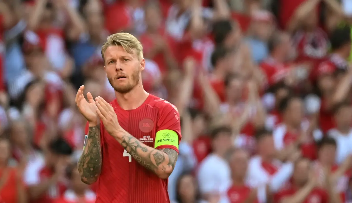 Bek timnas Denmark, Simon Kjaer bertepuk tangan setelah bola dikeluarkan dari permainan untuk menghormati gelandang Denmark, Christian Eriksen selama laga Grup B EURO 2020 antara Denmark dan Belgia di Stadion Parken di Kopenhagen, Kamis (17/6/2021). (Jonathan NACKSTRAND / POOL / AFP)