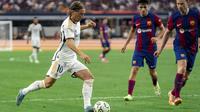 Gelandang Real Madrid Luka Modric (10) menggiring bola melawan gelandang FC Barcelona Frenkie de Jong (kanan) dan bek Andreas Christensen dalam laga pramusim bertajuk Soccer Champions Tour di AT&T Stadium, Texas, Amerika Serikat, Minggu (30/7/2023) dini hari WIB. (AP Photo/Jeffrey McWhorter)