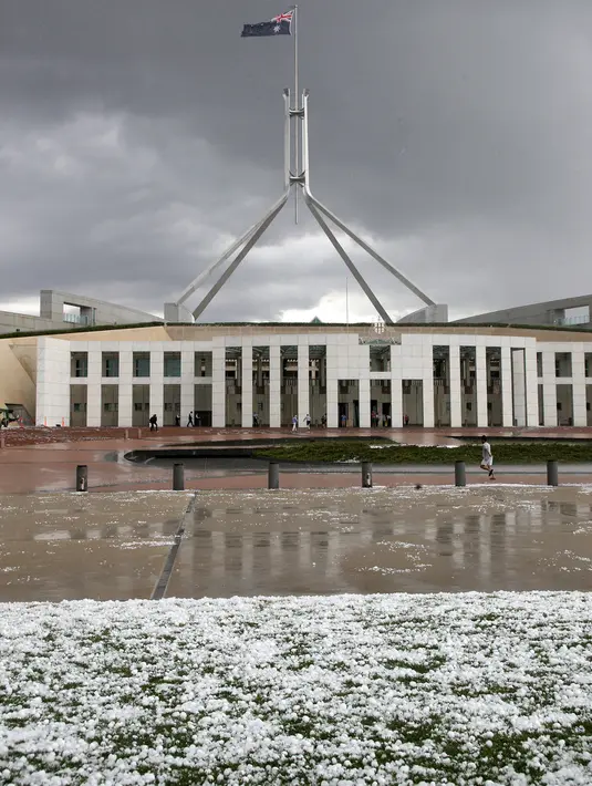 Es sebesar bola golf berserakan di luar Gedung Parlemen setelah badai menghantam Canberra, Senin (20/1/2020). Badai petir dan hujan es menerjang bagian wilayah pantai timur Australia setelah sebelumnya badai debu melanda daerah-daerah yang dilanda kekeringan. (AP/Rod McGuirk)