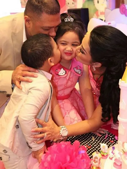 "Serbu kiss Amora" tulis raullemos06 saat KD, Raul beserta putranya saat bareng-bareng mencium putrinya. Pada pesta bernuansa pink itu mengusung konsep Hello Kitty sesuai permintaan Amora. (Instagram/raullemos06)