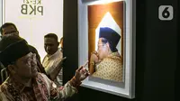 Ketua Umum PKB Muhaimin Iskandar meninjau pameran Satu Dekade Haul Presiden ke IV Republik Indonesia KH Abdurrahman Wahid atau Gus Dur di Kantor DPP PKB, Jakarta, Rabu (15/1/2020). Pameran sekaligus lomba foto ini diikuti oleh puluhan fotografer dari seluruh Indonesia. (Liputan6.com/Faizal Fanani)